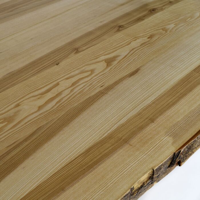 Dieses Detailbild zeigt die einzigartige Maserung der Messivholz Tischplatte und die Kante mit der Baumrinde.