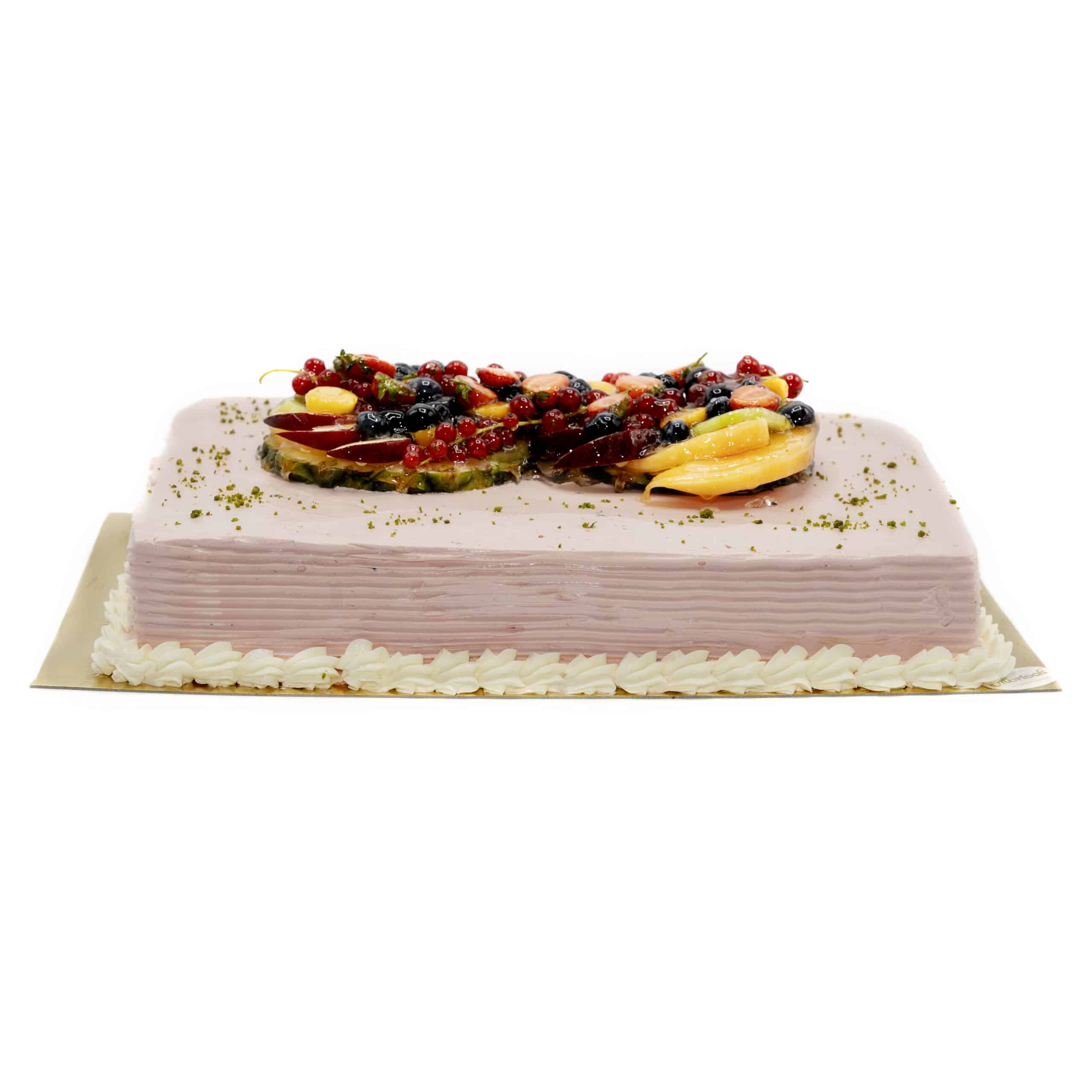 Hier ist eine rechteckige, rosane Torte zu sehen. Der untere Rand ist mit Sahnetupfen dekoriert. Mittig oben befindet sich eine exotische Obstmischung, umschmeichelt von Pistazien-Bröseln.